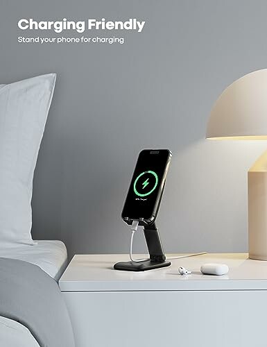 Smartphone on charging stand by bedside with lamp